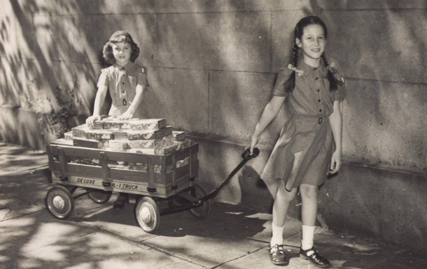 girl scouts with cookies in a wagon
