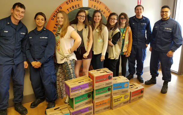 girl scouts and service members with girl scout cookies