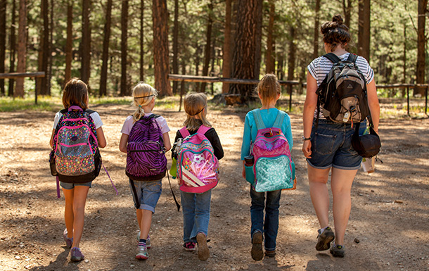 group of young girl scouts and volunteer walking outside