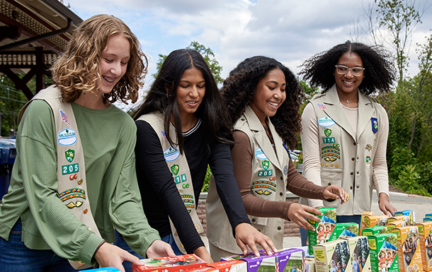 older girl scouts setting up cookie booth