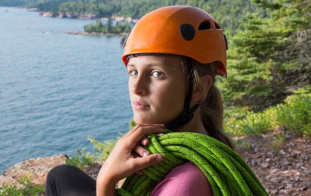 older girl scout getting ready to rock climb